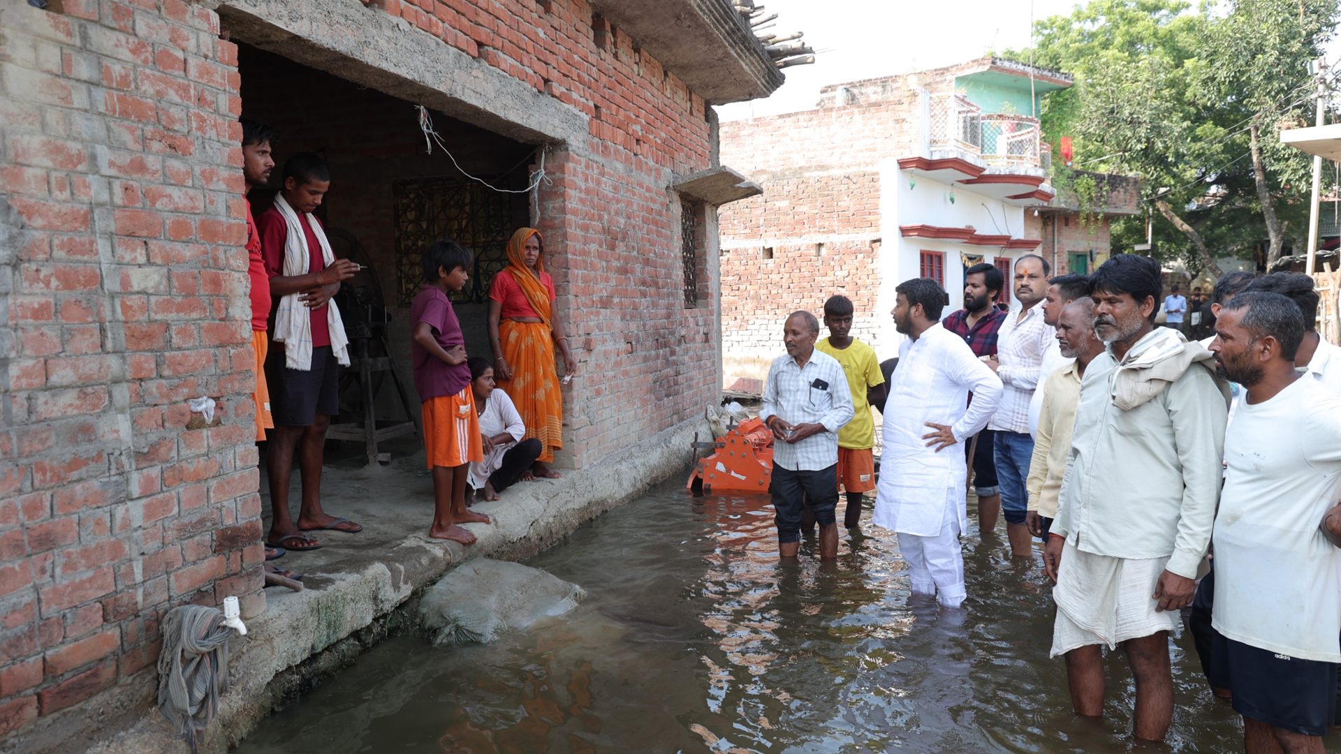 Lalan Kumar standing in floodwater with affected families